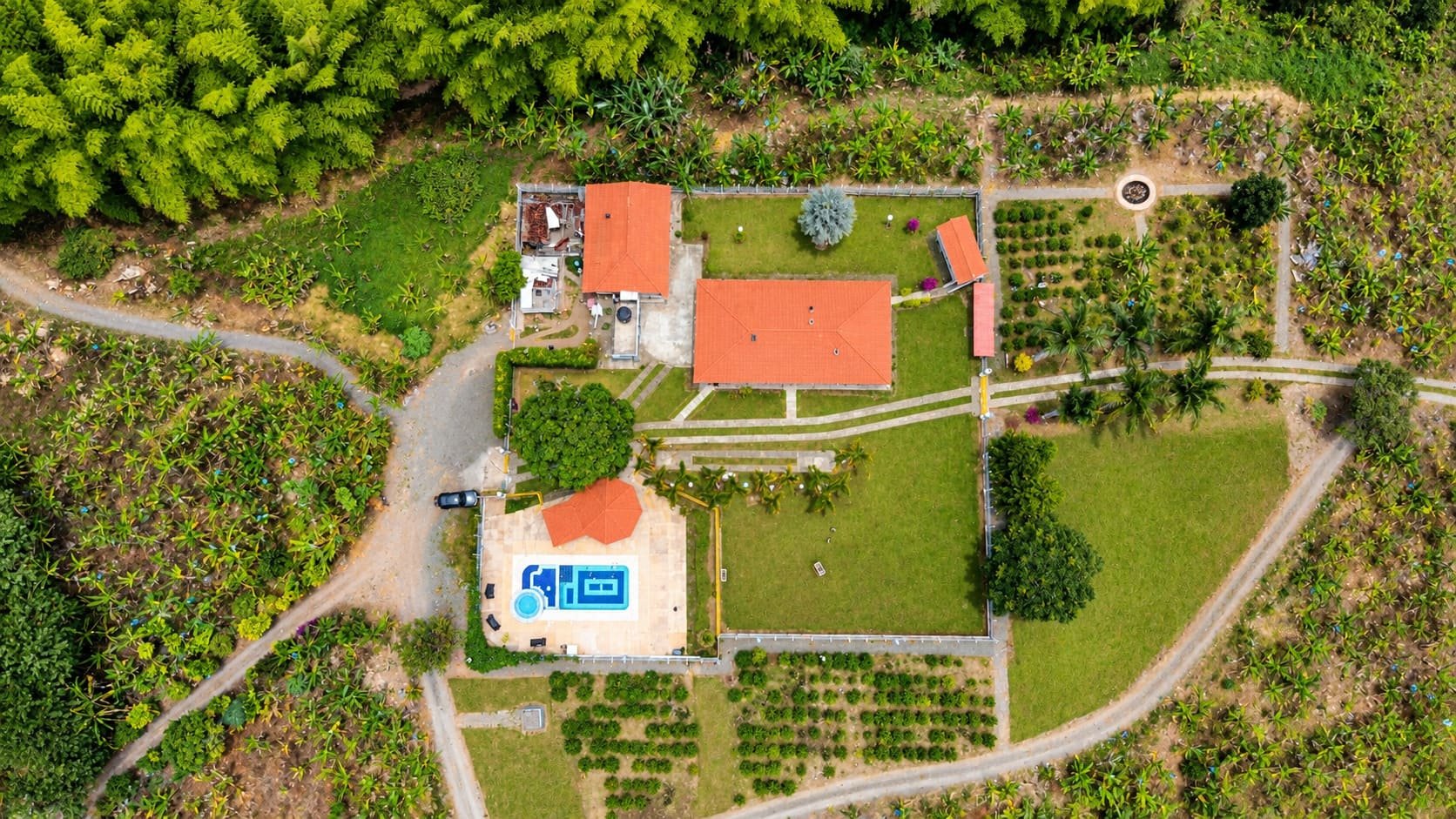Vista aérea de la finca cerrada, con los parqueaderos y la entrada