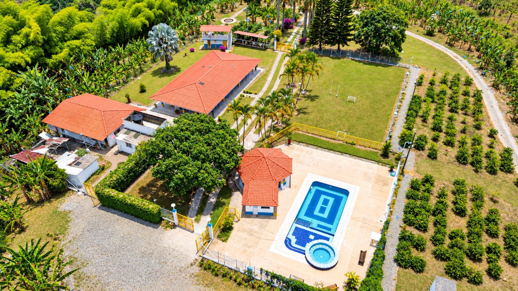 Vista aérea de la finca, con la casa principal, el kiosko, la piscina y la cancha