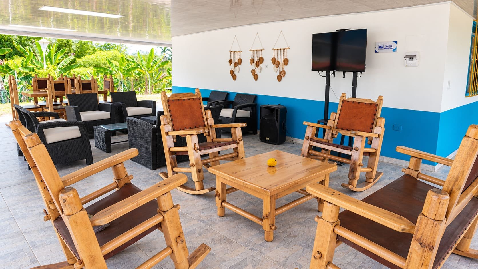 Kiosko de actividades sociales con mecedoras, televisor y bafle